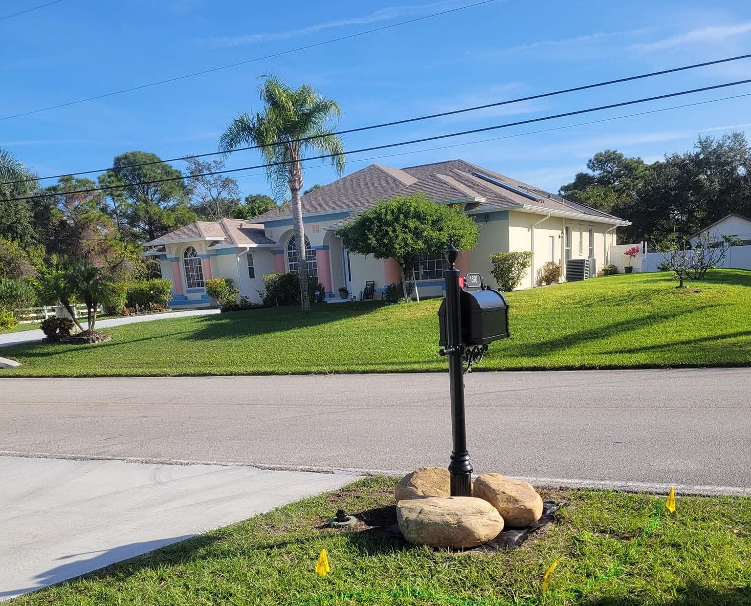 Before: plain lawn around a black mailbox with three boulders