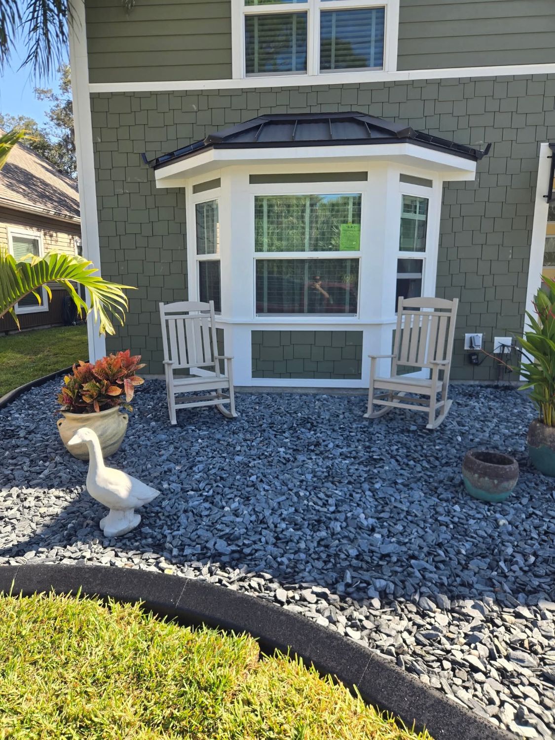 Gray rock garden in front of a porch with two rocking chairs